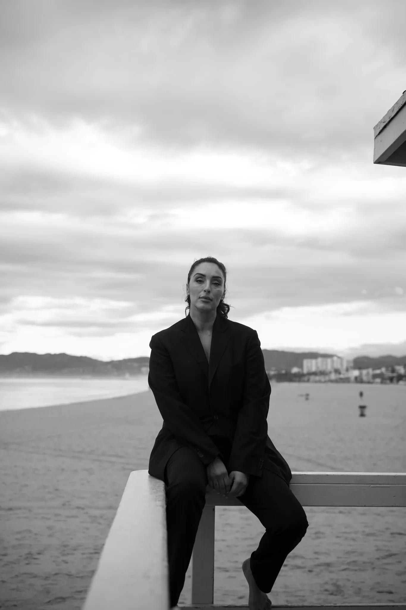 Model captured in preparatory moment, minimal styling, clean composition, anticipation and stillness before movement