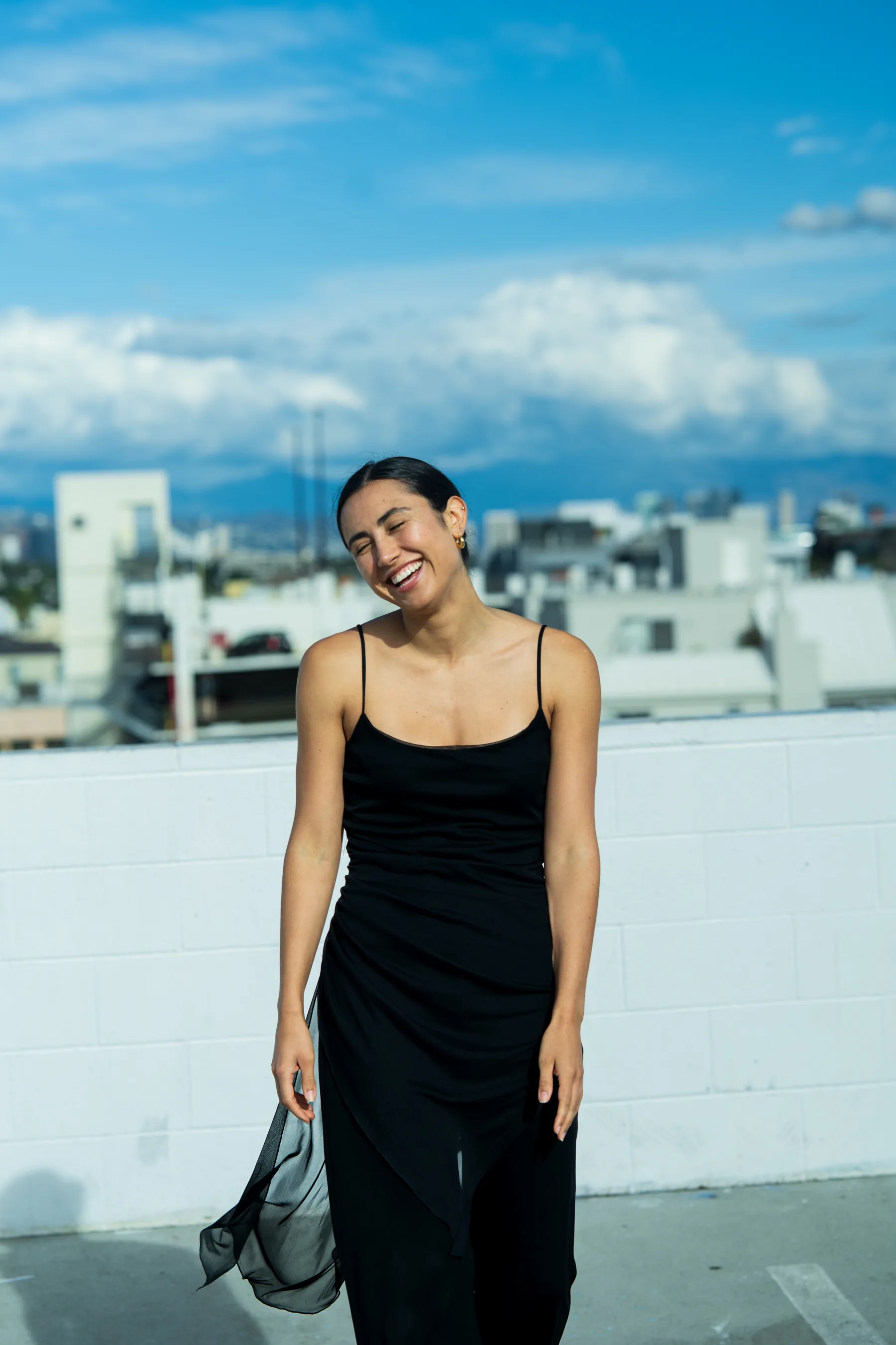 Candid fashion moment between styled poses, natural body language, editorial setting, authentic and unguarded